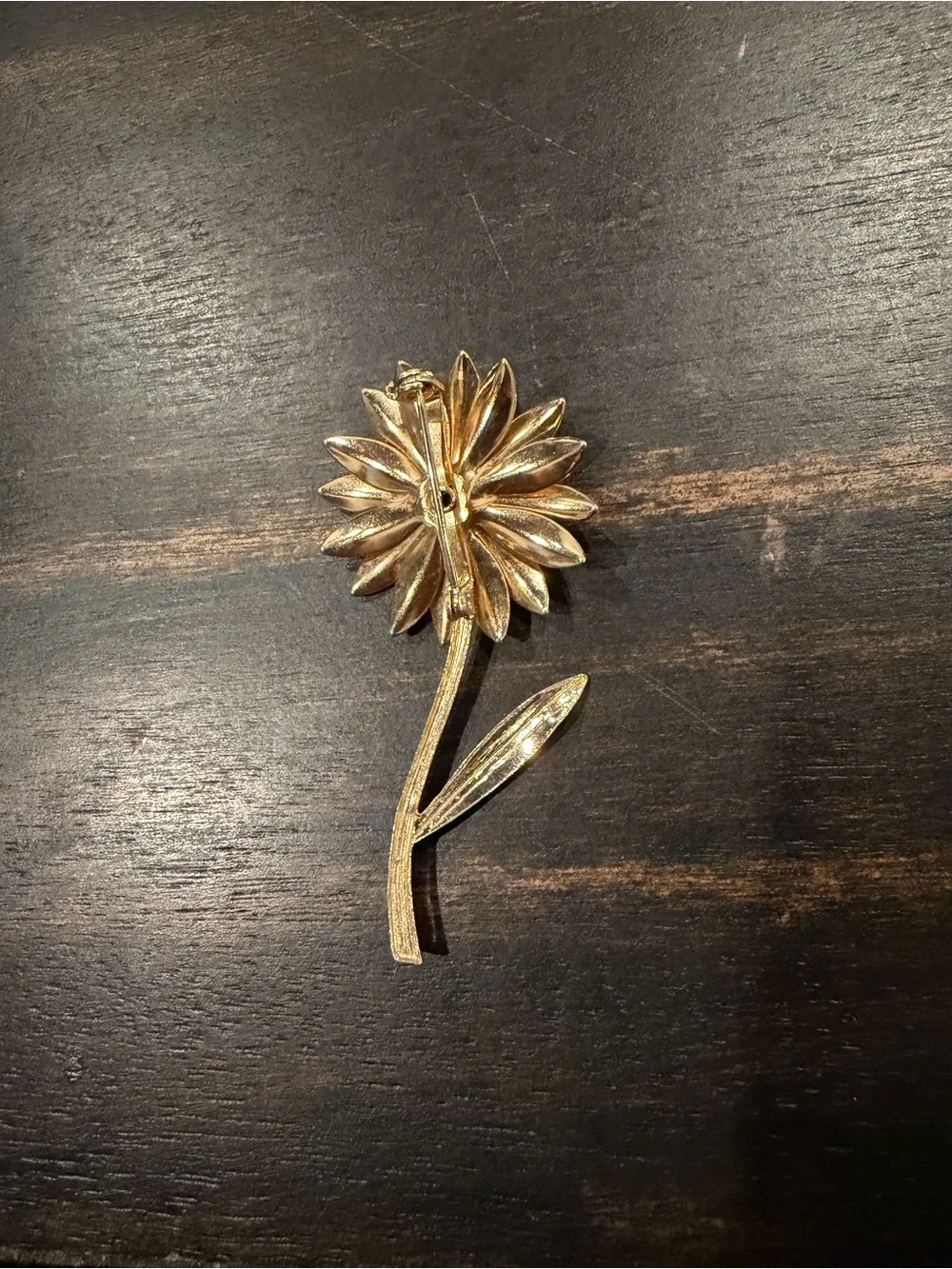 Gold tone sunflower brooch with blue center stone